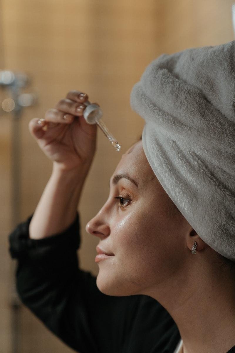 Woman applying peptides to her face