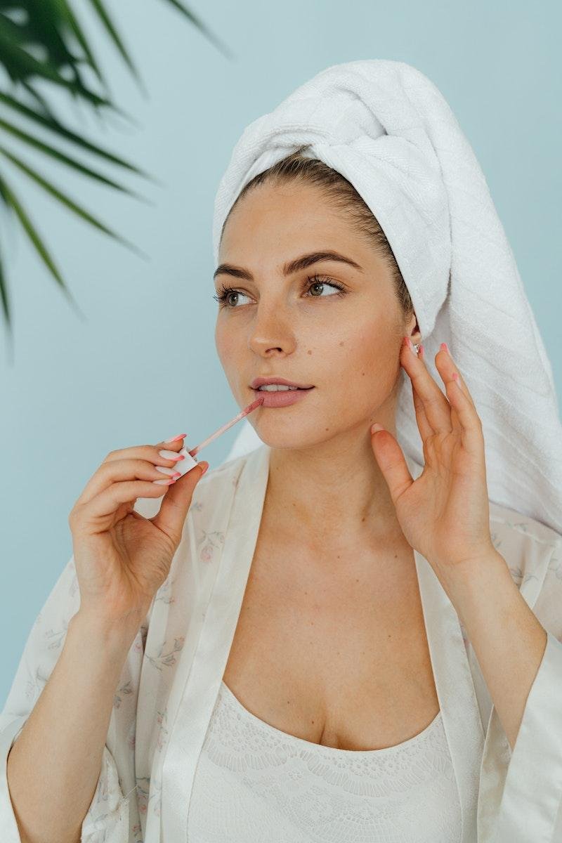 Woman in White Head Towel Applying Lip Care Products